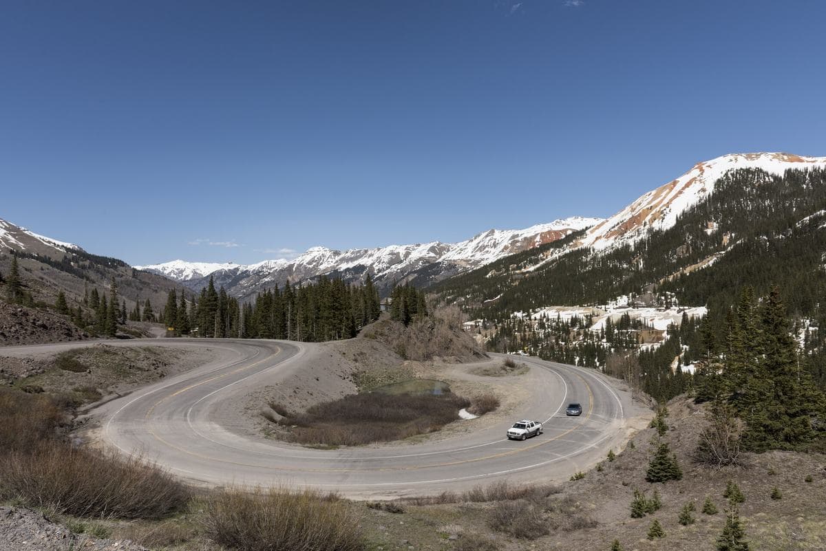 A winding mountain highway beneath snow-capped peaks