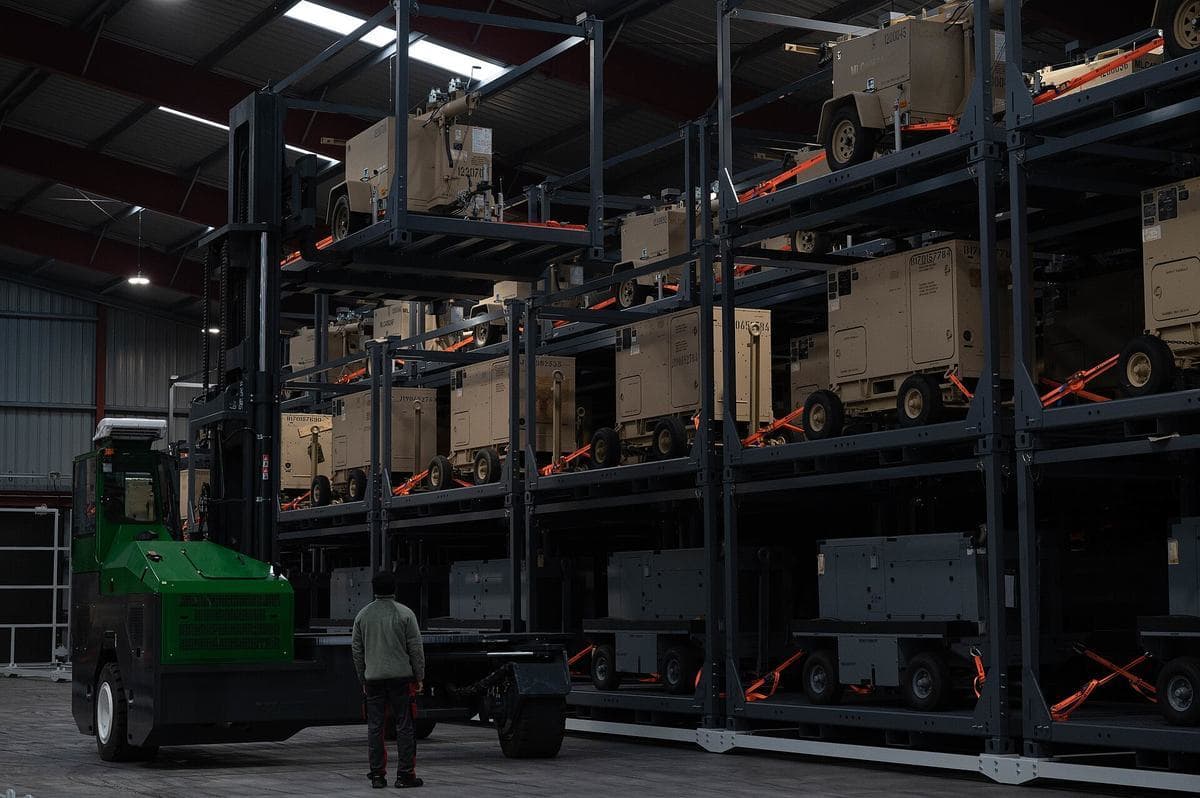 A forklift beside tall storage racks in a warehouse